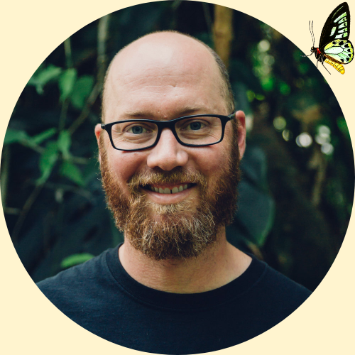 A photo of garden manager Kurtis posing in the butterfly gardens